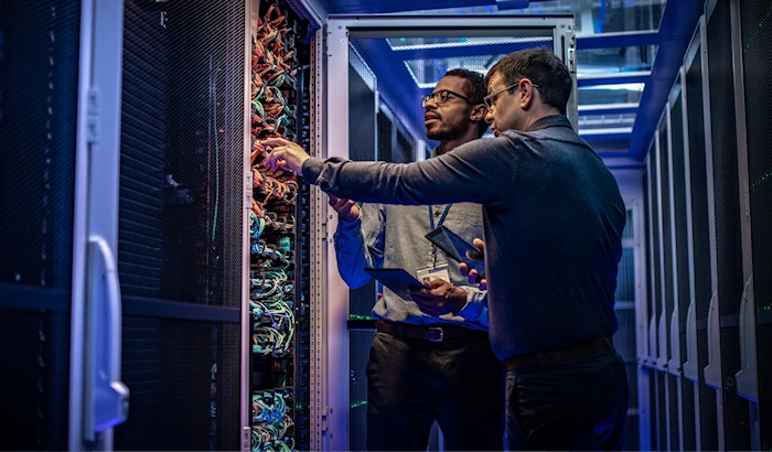 Two people monitoring a server farm