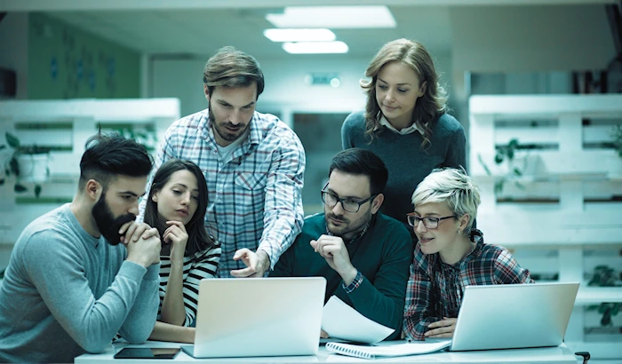 Web development team looking at laptop